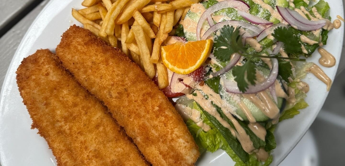 Crispy fish fillets with fries, salad, and sauce served fresh at Makai Seafood Market in San Diego.
