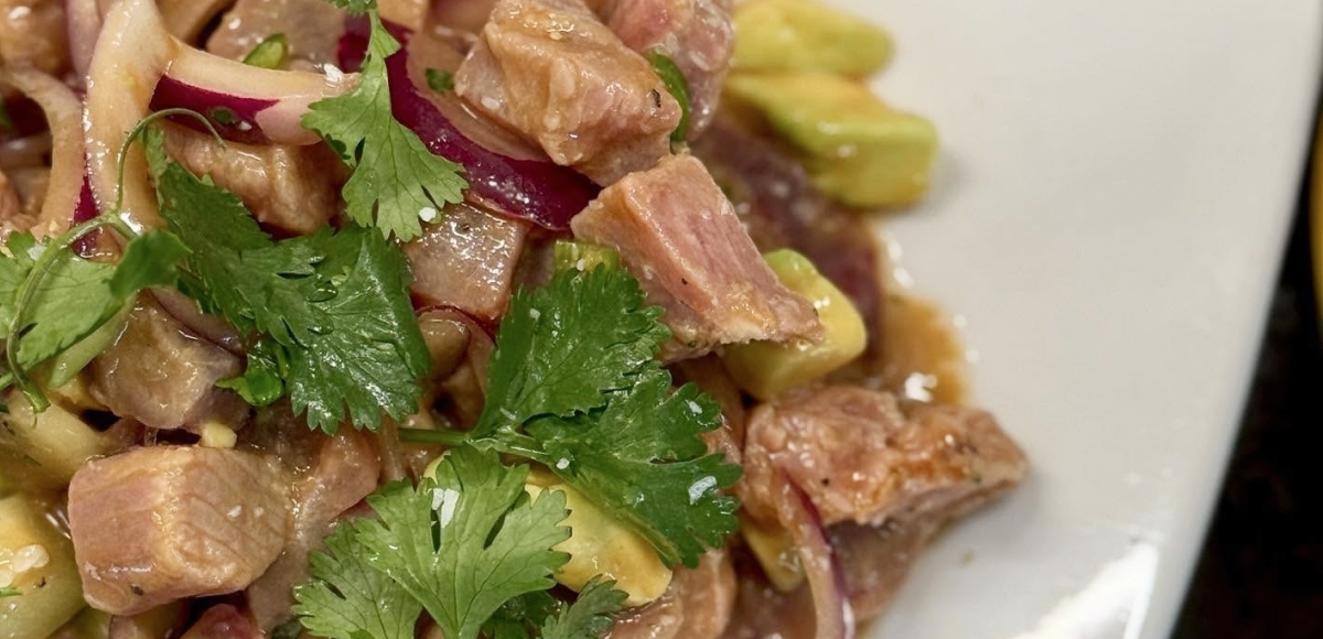 Hawaiian-style tuna poke with onions, cilantro, and soy dressing prepared fresh at Makai Seafood Market.