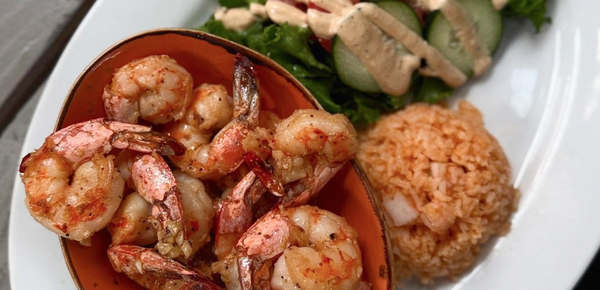 Juicy grilled shrimp served with rice and fresh herbs at Makai Seafood Market in San Diego.